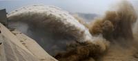 Water coming out from dam onto dry ground