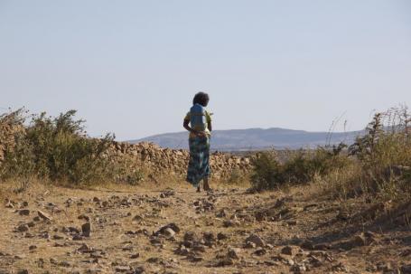Young woman carrying water home in Ethiopia. Access to safe water is essential to human health. Photo by waterdotorg